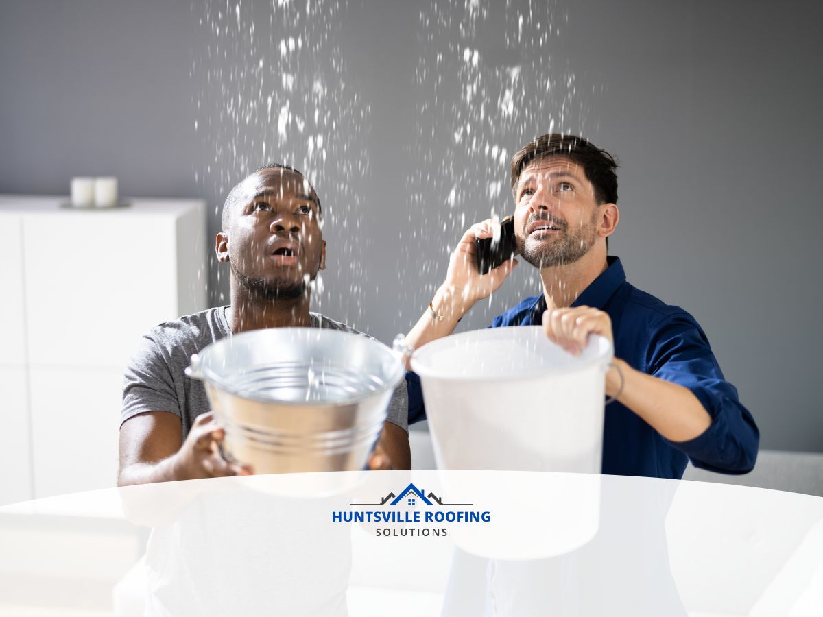 Homeowners using buckets to catch water leaking through a ceiling during a roof leak