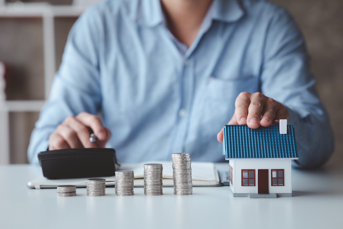 Calculating monthly roof payment options for a North Alabama home using a house model and coins