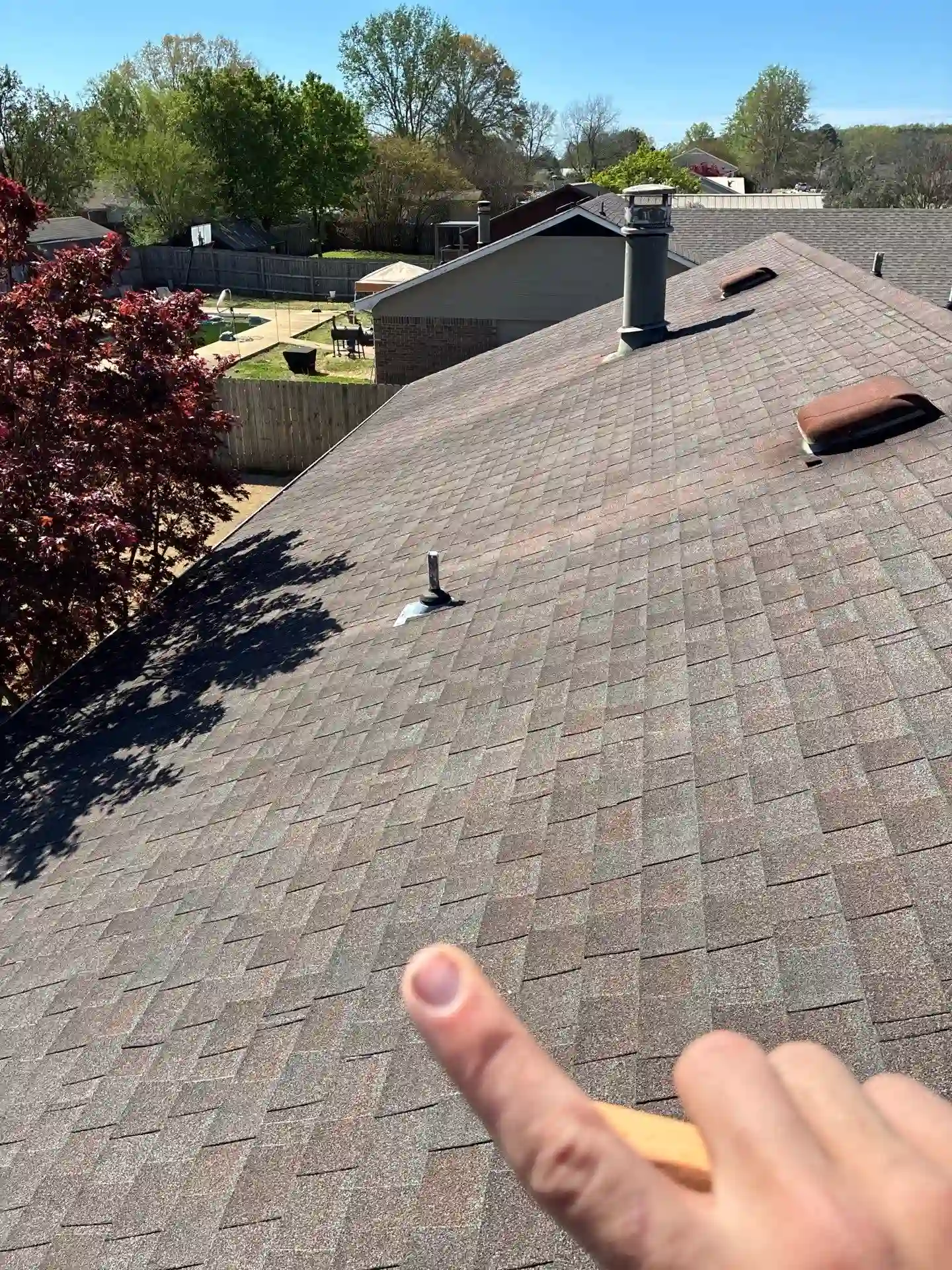Roofer pointing out a problem area during a scheduled roof maintenance inspection on a North Alabama home