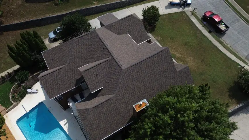 New dark shingle roof on a home overlooking a backyard pool