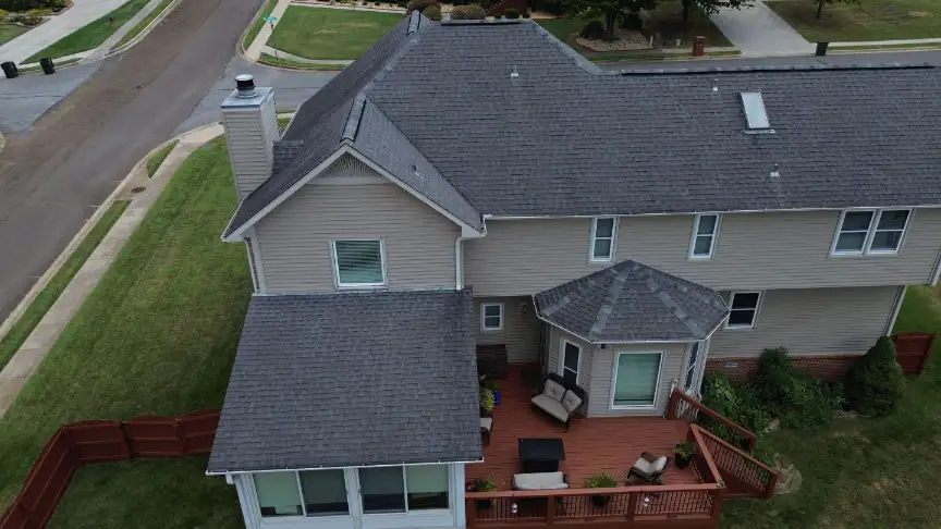 Beige two-story home with a new roof, wooden deck, and a fenced backyard