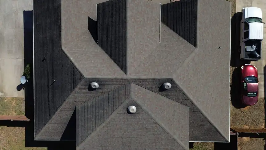 New dark shingle roof with clean geometric ridges and vents