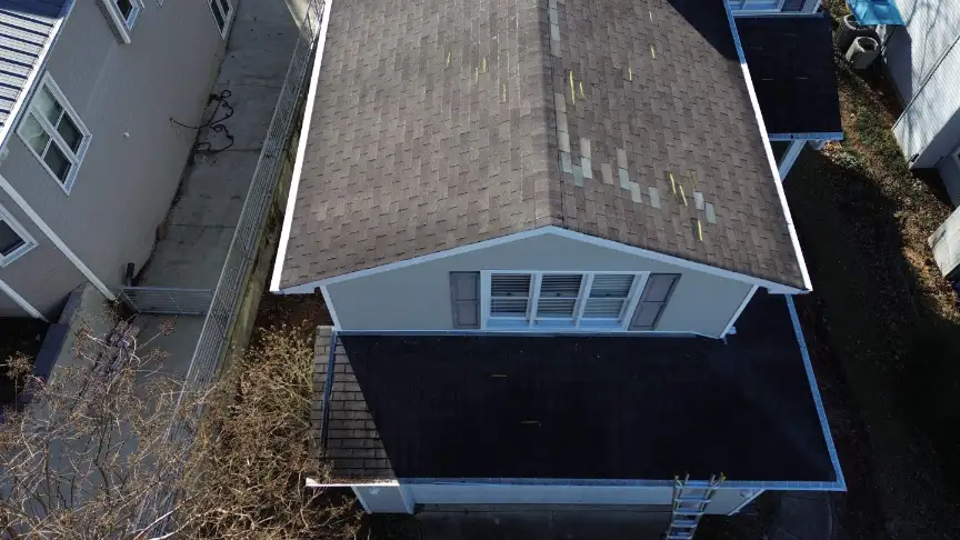 Aerial view of residential roof with missing shingles near the ridge in North Alabama