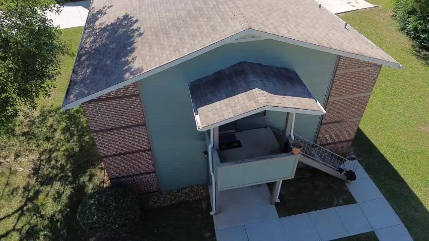 Sloped roof replacement on a blue two-story building in Hazel Green