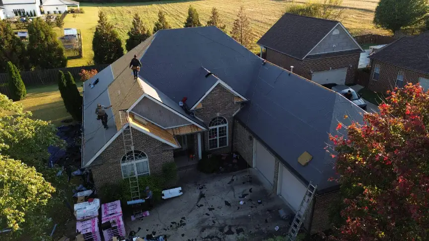 Huntsville roofing company workers completing a full residential roof replacement on a large brick home.