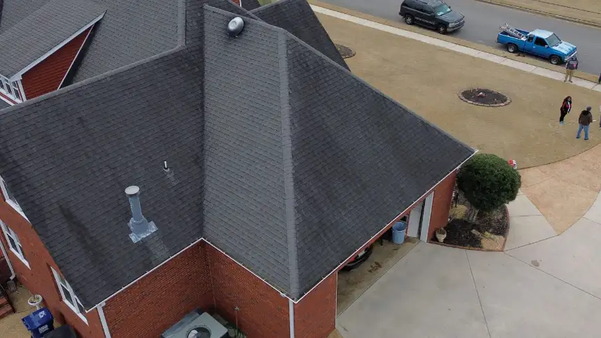 Finished gray shingle roof on a brick home with a curving driveway