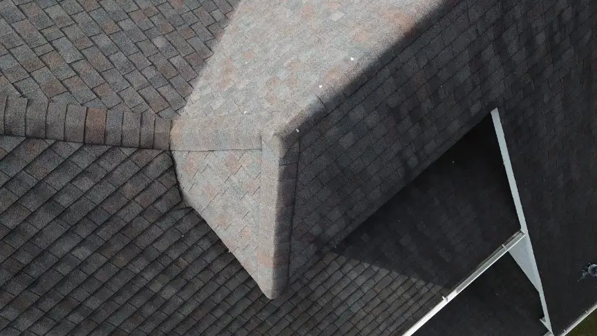 Detail of a new dark asphalt shingle roof valley and ridge