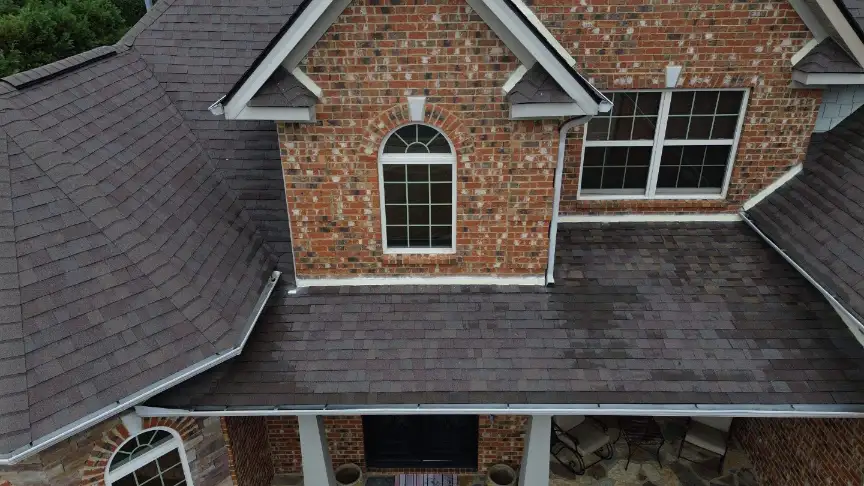 New dark gray shingle roof with arched windows on a brick house