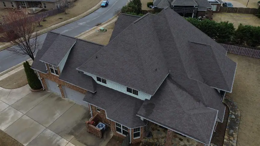 Complex gray shingle roof installed on a large brick Huntsville home by expert local roofers.