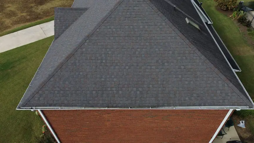Aerial view of a completed gray asphalt shingle roof on a brick Huntsville home