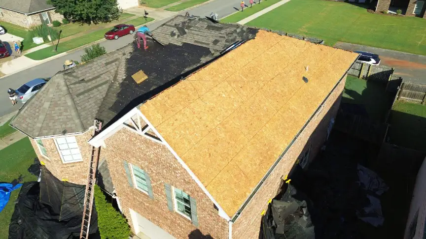 Roofers in Hazel Green AL tearing off old shingles and inspecting decking