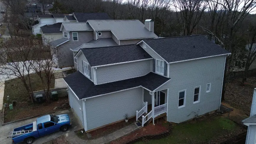 Two-story home with a new black shingle roof and a pickup out front