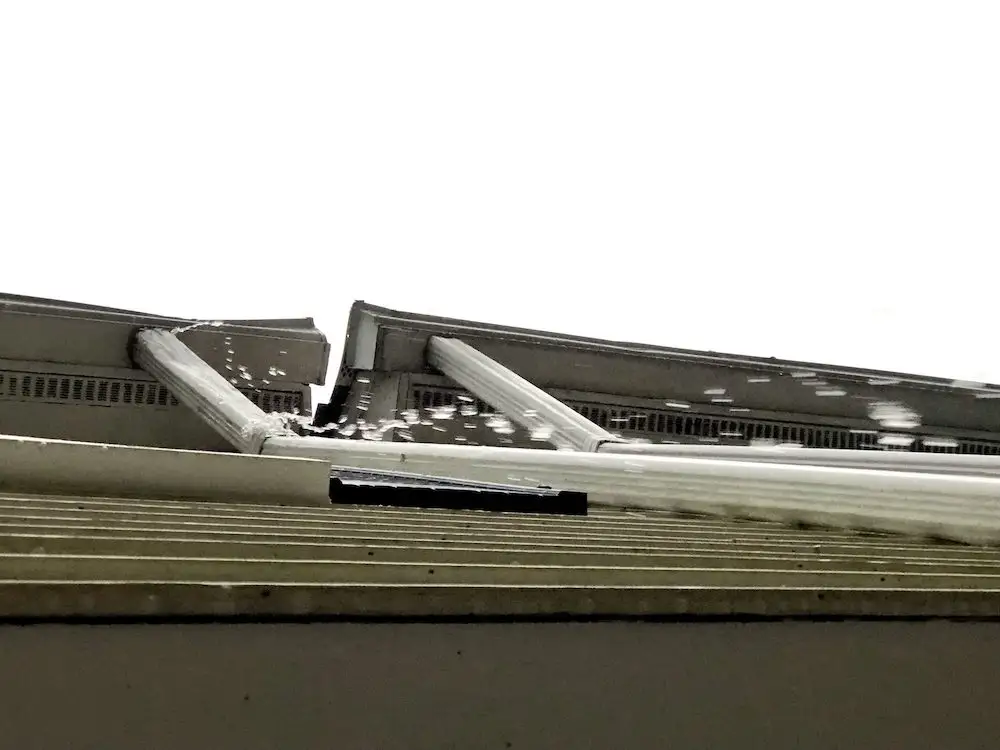 Rain overflowing roofing gutters. Gutter needs repair work