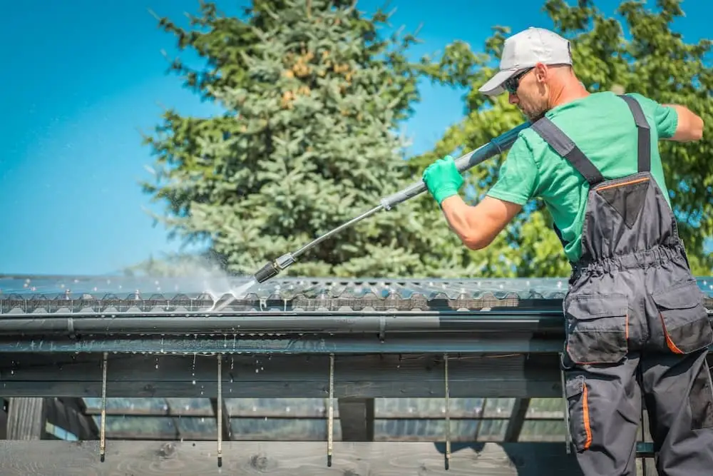 Professional gutter cleaning service removing debris from a house