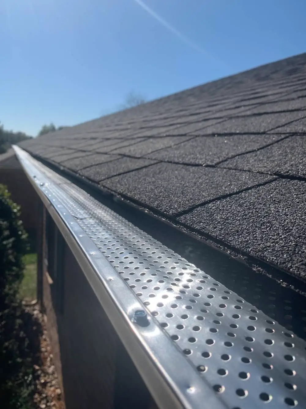 Roof of a house showing new gutter and leaf guard installation